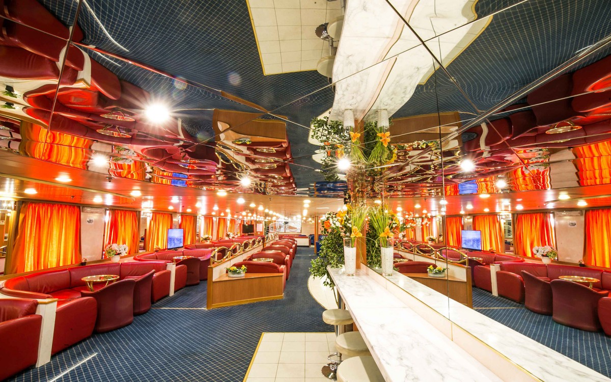 Main lounge and bar with red leather seating aboard the AF Marina ferry